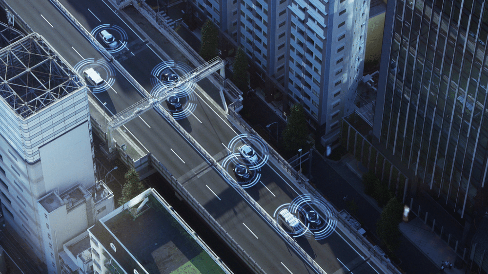 A top-down view of a city street at night with three vehicles, each highlighted by circular ADAS graphics representing sensors and connectivity. The advanced driver-assistance systems (ADAS) in these vehicles are actively scanning the environment for navigation and safety.
