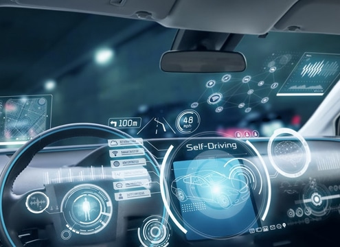 Interior view of a self-driving car with a detailed ADAS interface on the windshield. The dashboard displays speed, navigation, and vehicle status, while the windshield projects interactive graphics for autonomous driving functions, such as adaptive cruise control and lane-keeping assistance.